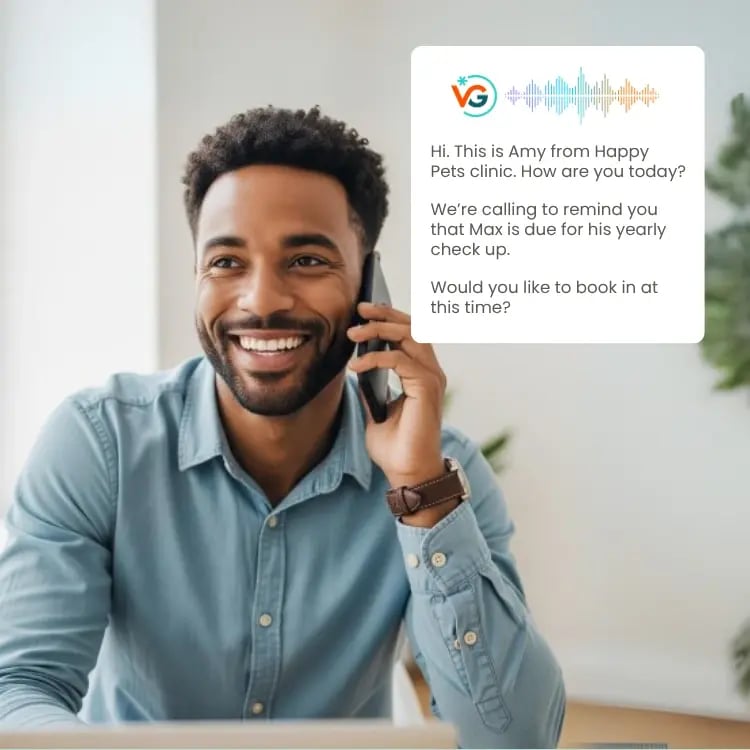 Man sitting at a desk smiling and on his smartphone. Showing an example of VG Connect making an outbound call.